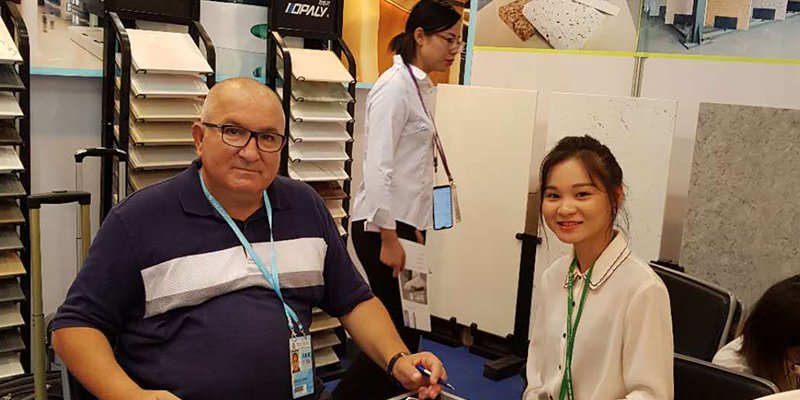 A designer showing a client custom quartz samples in a showroom