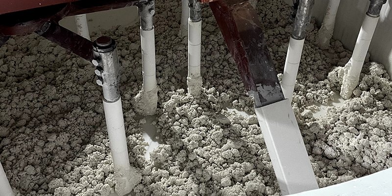 An industrial mixer combining quartz, resin, and pigments.