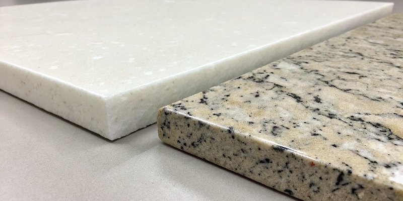alt text="A close-up of a white quartz slab and a granite slab side by side"