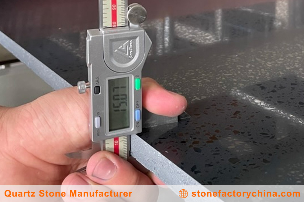 Precise Measurement for Quartz Slabs A person using a tape measure on a large quartz slab to demonstrate precision.